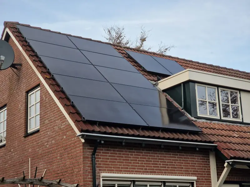 Zwarte zonnepanelen op het pannendak van een woning